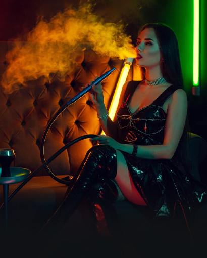 Woman enjoying a hookah session in a modern lounge with vibrant neon lighting, exhaling smoke while seated on a tufted sofa, creating a stylish nightlife and entertainment atmosphere.